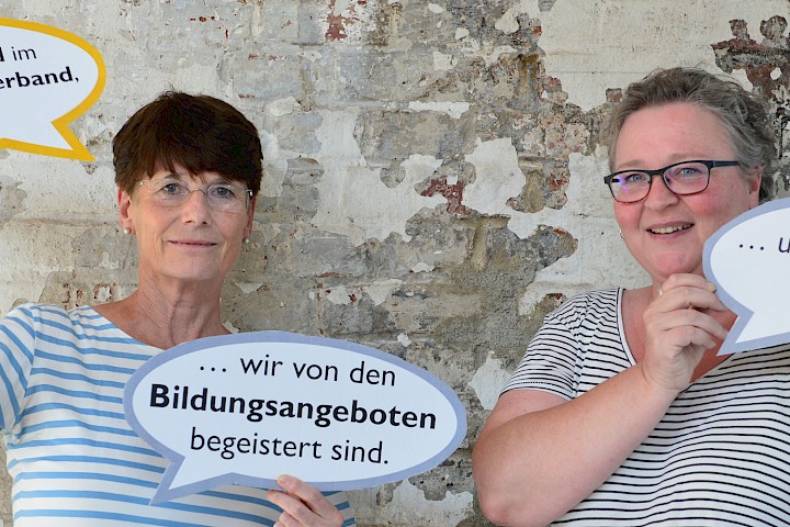 Zwei Frauen halten Sprechblasen hoch